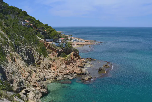 De rotsachtige kustlijn van Les Rotes bij Dénia met helder blauw water