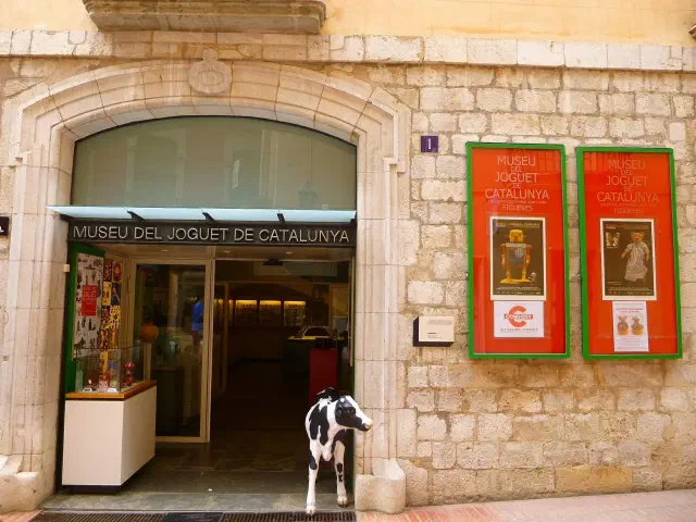 Ingang van het Museu del Joguet de Catalunya in Figueres met de koe-sculptuur Ingang van het Museu del Joguet de Catalunya in Figueres met de koe-sculptuur