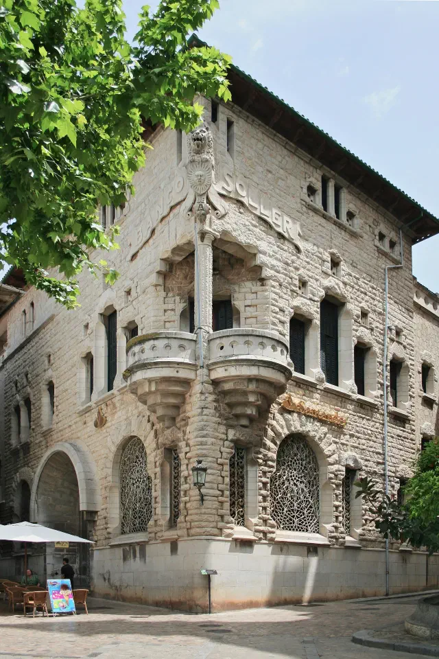 De Modernista Banco de Sóller op de Plaça Constitució met smeedijzeren puibalkons en stenen gevel ontworpen door Joan Rubió De Modernista Banco de Sóller op de Plaça Constitució met smeedijzeren puibalkons en stenen gevel ontworpen door Joan Rubió
