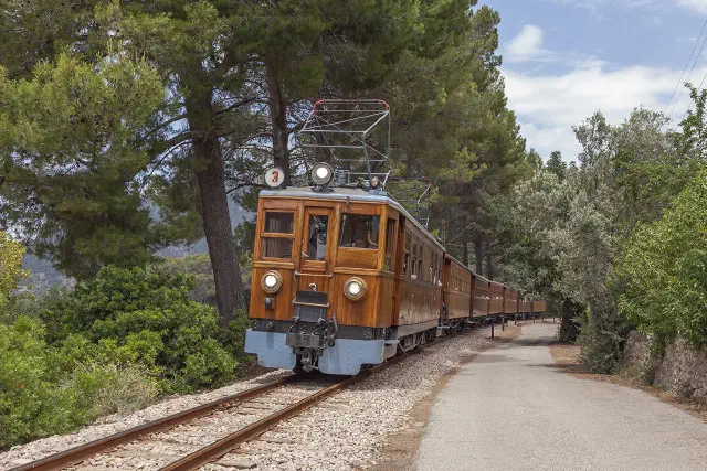 De historische houten Tren de Sóller uit 1912 onderweg door de dennenbossen tussen Palma en Sóller De historische houten Tren de Sóller uit 1912 onderweg door de dennenbossen tussen Palma en Sóller