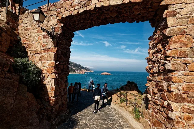 De ommuurde middeleeuwse Vila Vella van Tossa de Mar met torens boven de zee De ommuurde middeleeuwse Vila Vella van Tossa de Mar met torens boven de zee